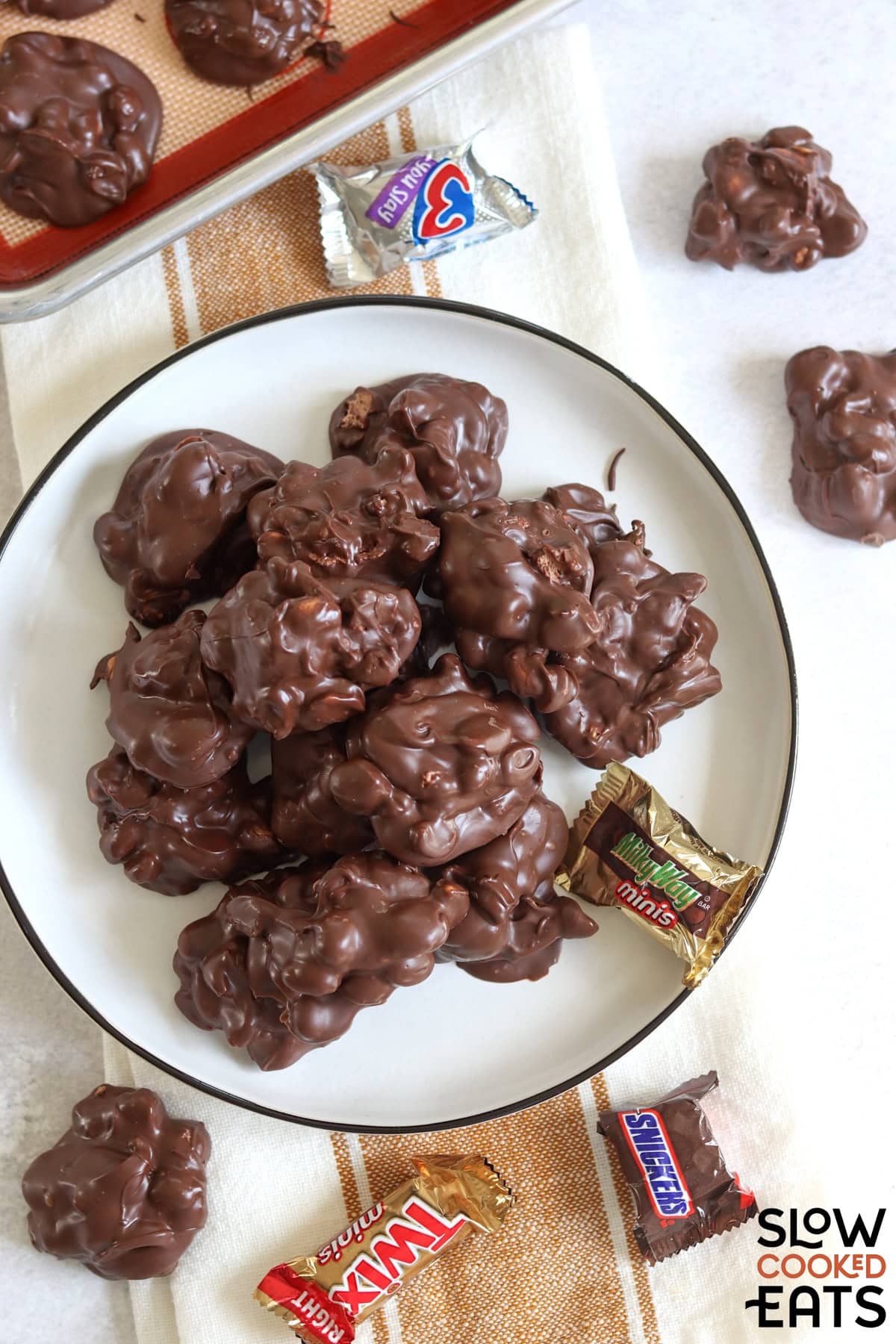 Crockpot chocolate candy bar bites on a white plate.