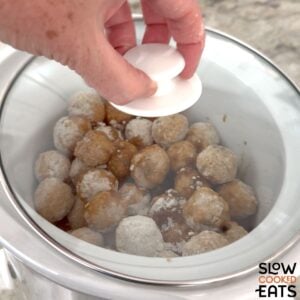 Slow cooking the crockpot French onion soup meatballs.