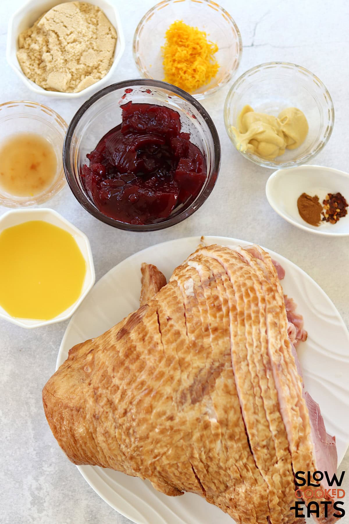 Cranberry orange crock pot ham recipe ingredients on a white marble countertop.