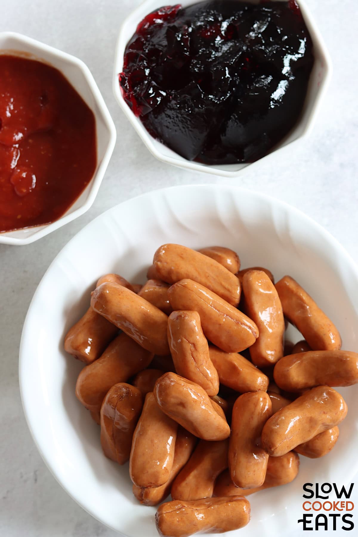 Ingredients needed for crockpot little smokies grape jelly on a white marble countertop.