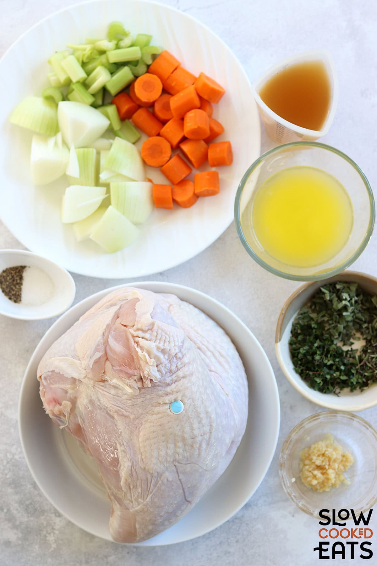 Ingredients needed to make herb butter slow cooker turkey breast on a white marble countertop.