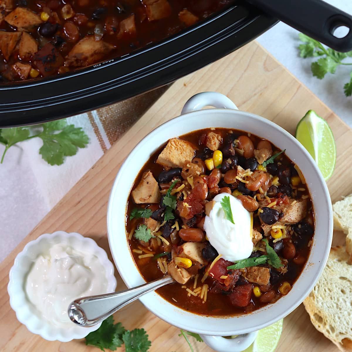 Leftover turkey chili crockpot recipe served in a white bowl and silver spoon.
