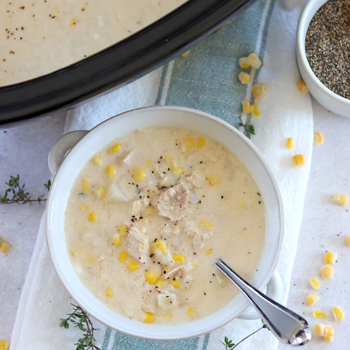 Leftover turkey corn chowder crockpot recipe served in a white bowl and silver spoon.