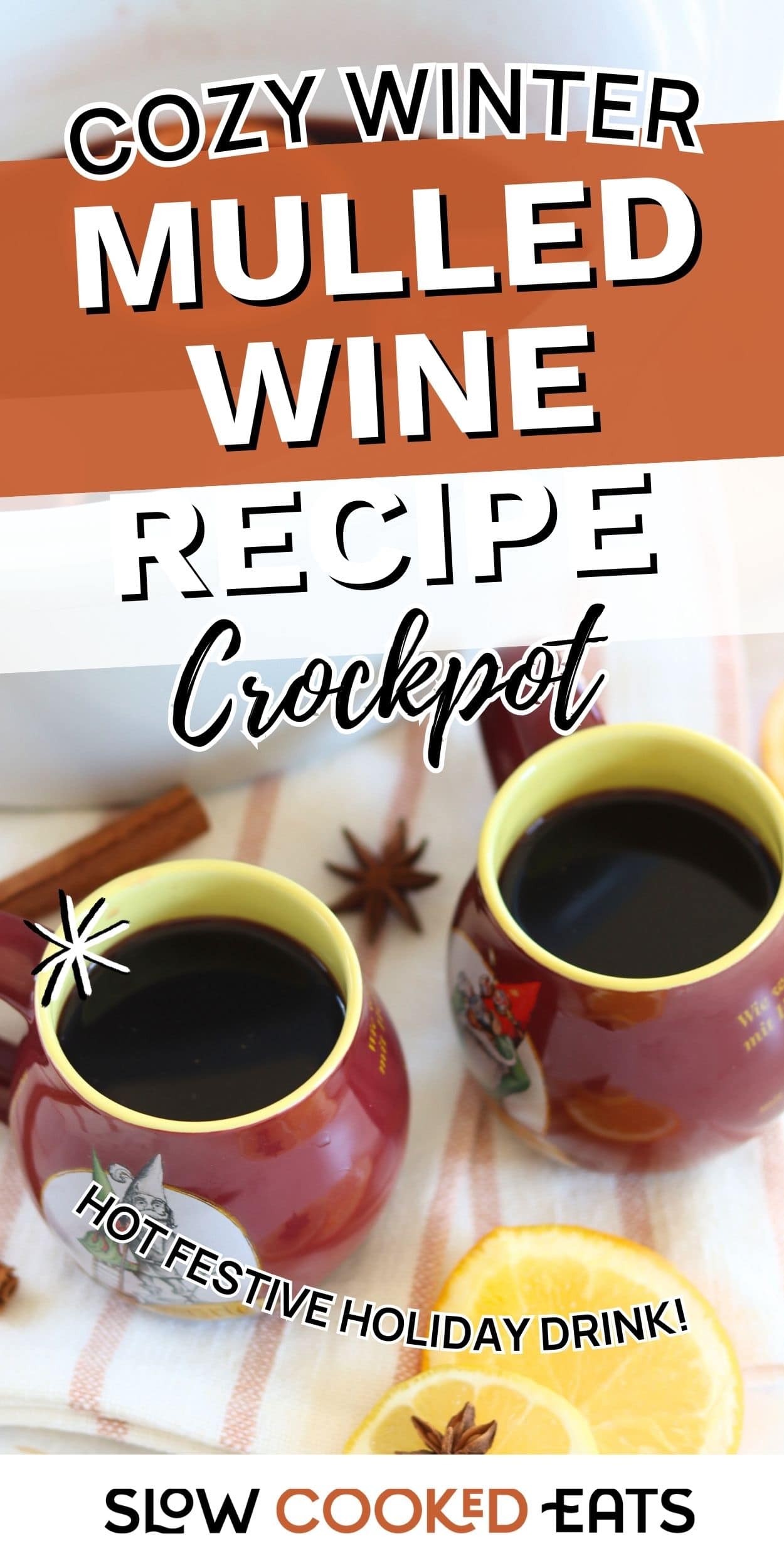 wo mugs of hot mulled wine made in a crockpot, surrounded by orange slices, cinnamon sticks, and star anise. Warm spiced wine holiday drink.