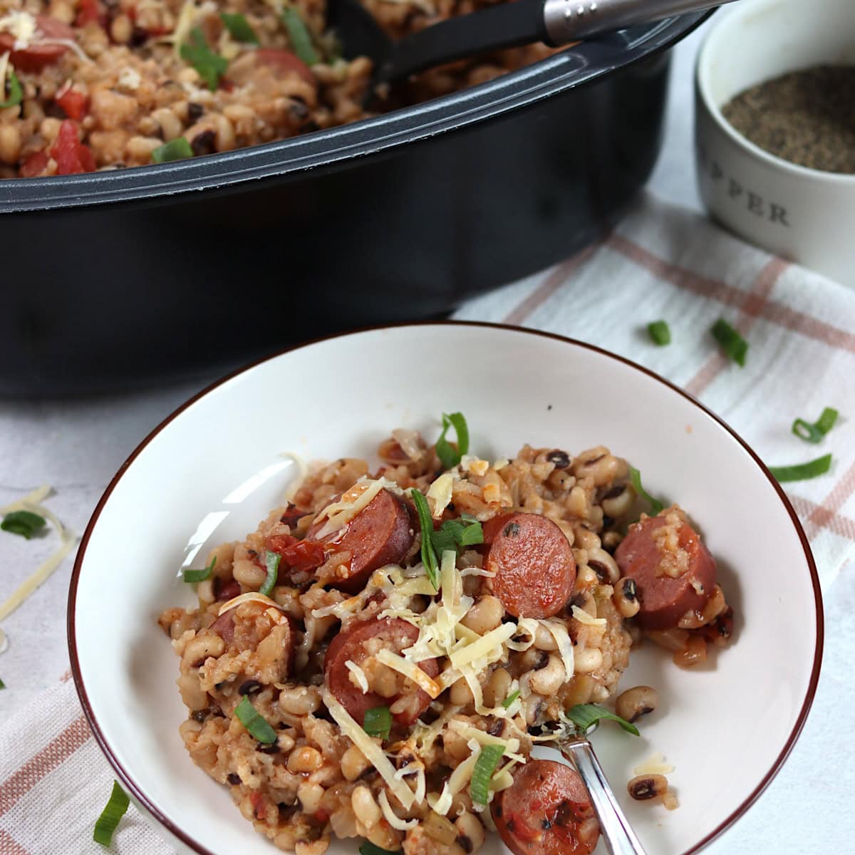 Crockpot hoppin' John served in a white round bowl and silver spoon.