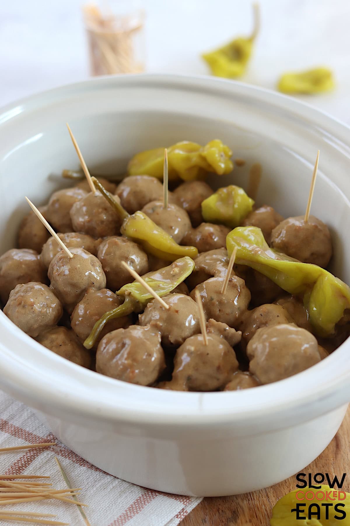 Mississippi meatballs crockpot recipe in a white oval slow cooker.