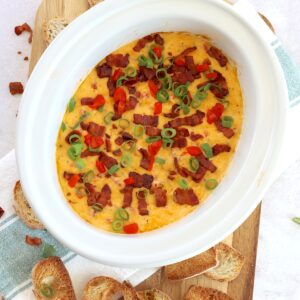 Hot pimento cheese dip crockpot recipe in a white oval slow cooker.
