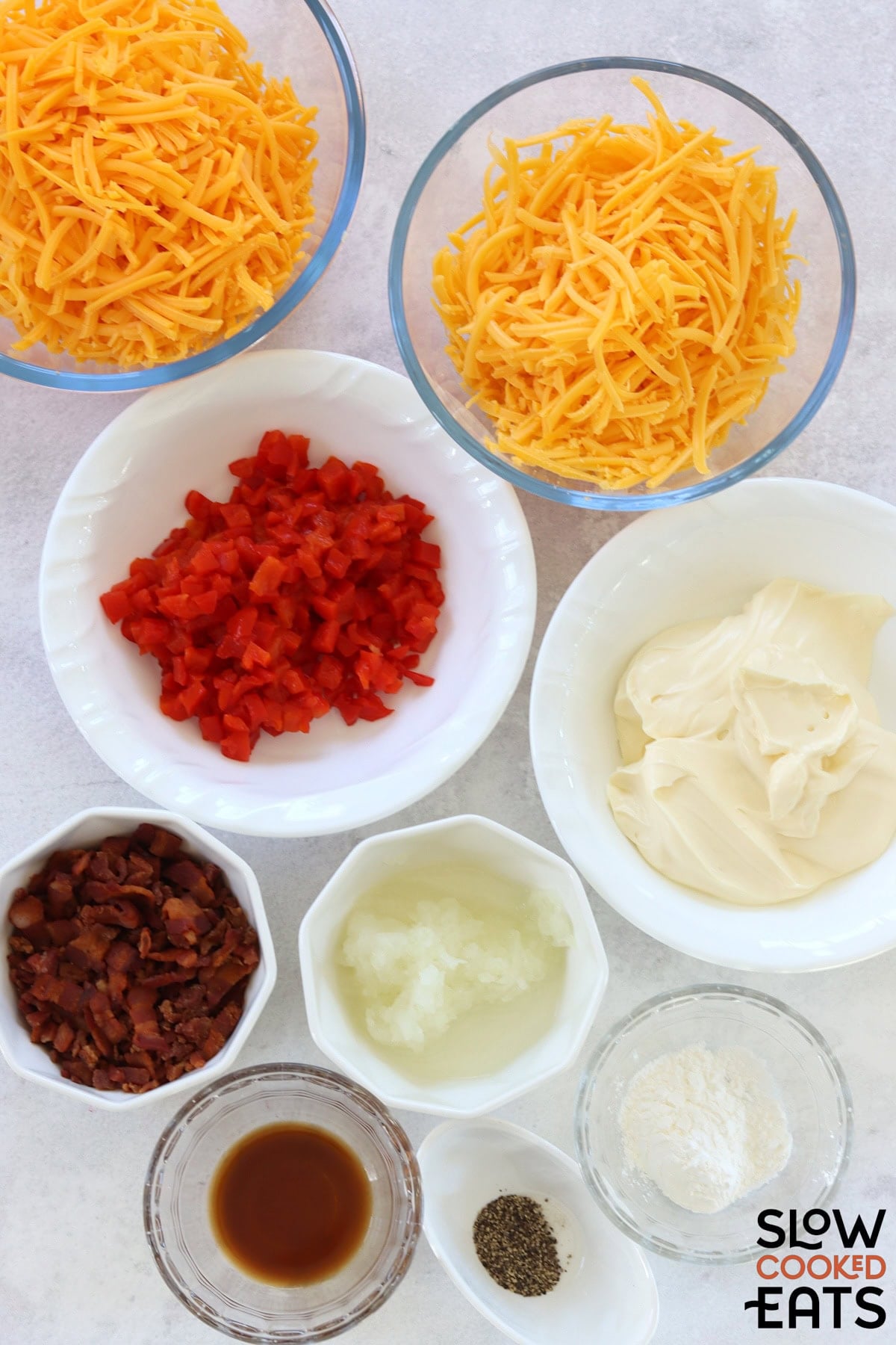 Ingredients needed to make hot pimento cheese dip crockpot on a white marble countertop.