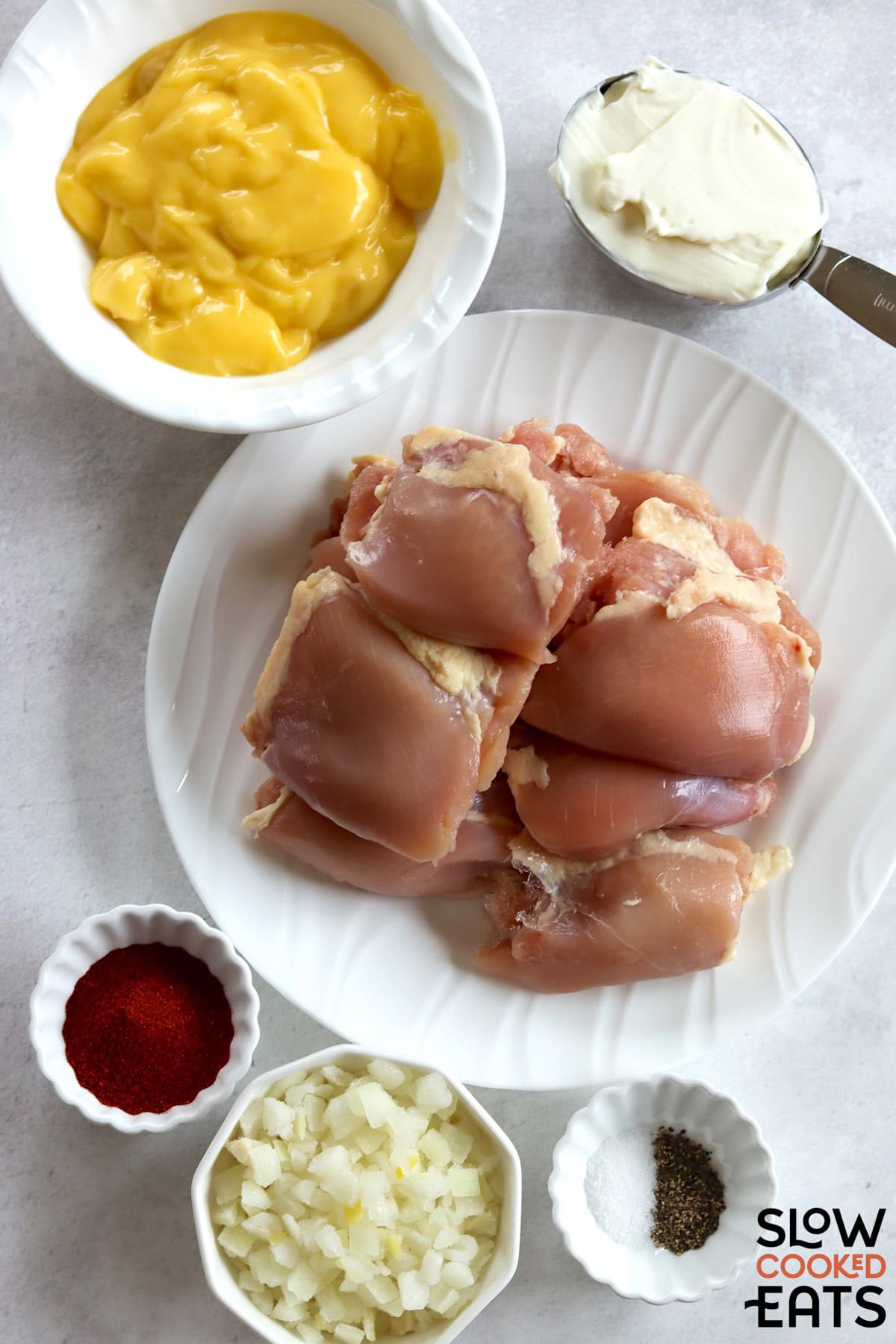 Ingredients needed to make crockpot chicken paprika on a white marble countertop