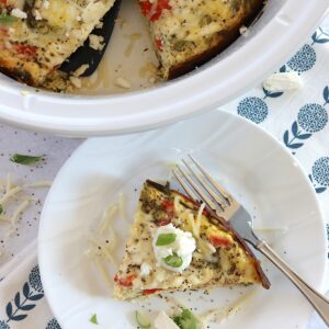 Mediterranean crockpot frittata served on a white round plate and silver fork.