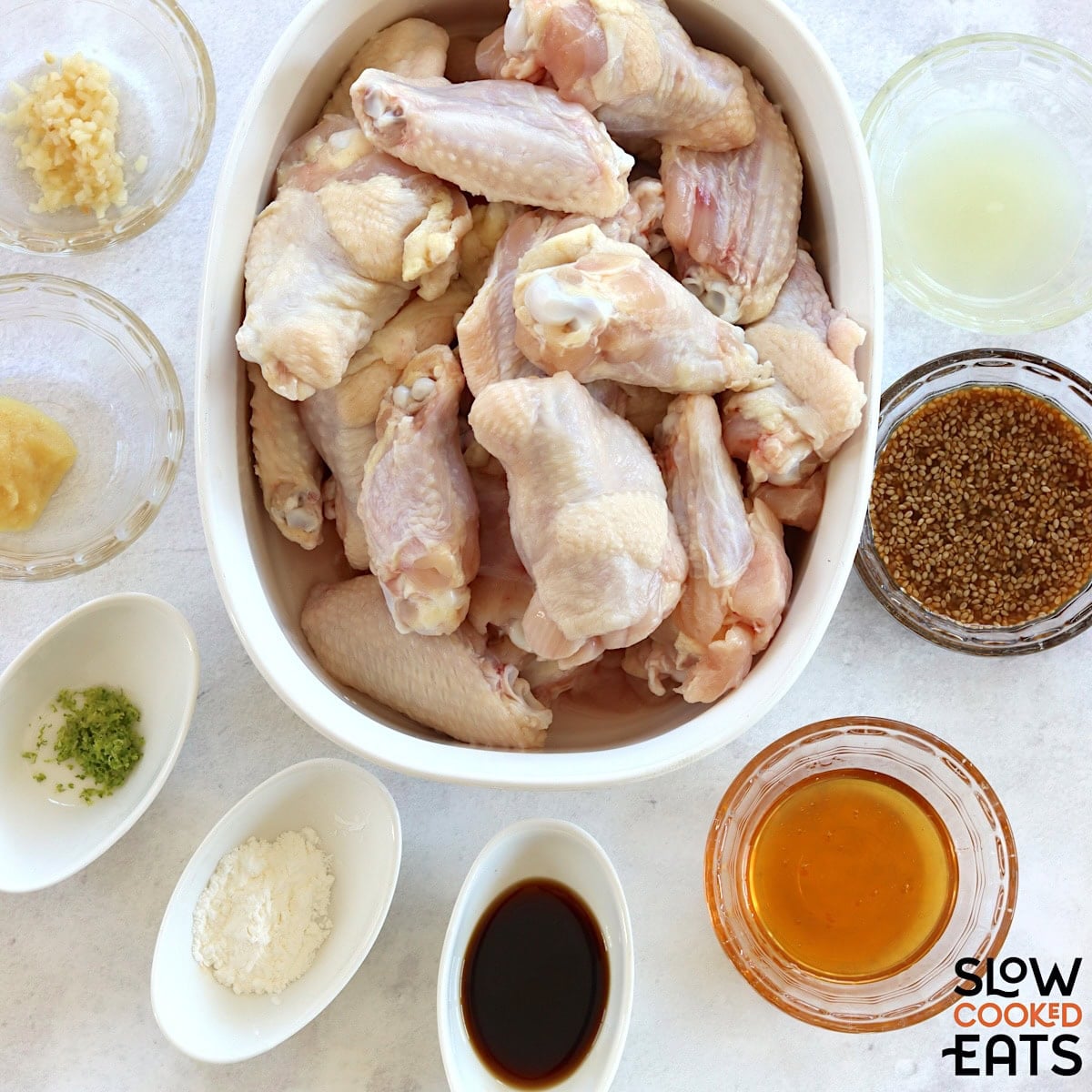Ingredients needed to make crockpot teriyaki chicken wings on a white marble countertop.
