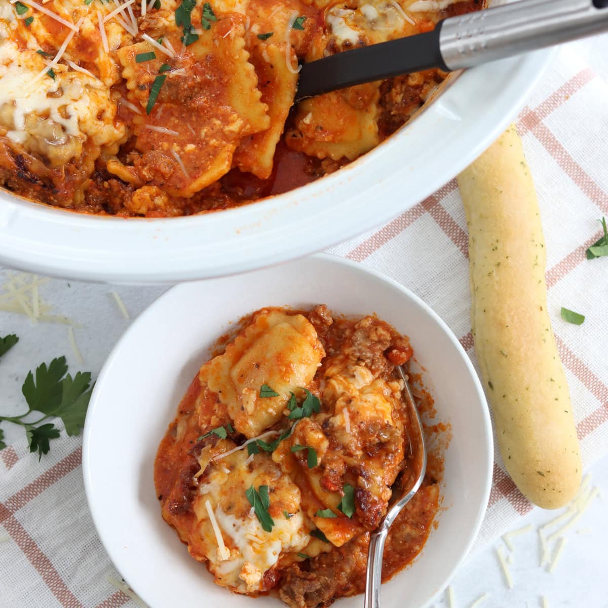 Crockpot ravioli lasagna served in a small white round bowl and silver fork.