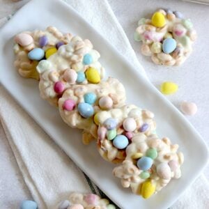 Crockpot Easter candy clusters arranged on a long white rectangle plate.