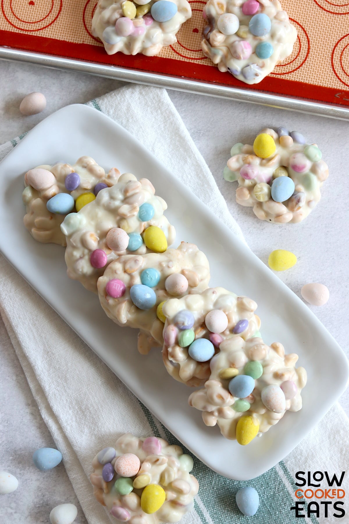 Crockpot Easter candy clusters arranged nicely on a long white rectangular plate.