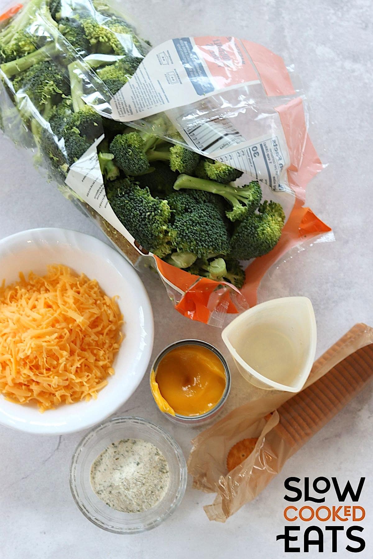 Ingredients needed for making crockpot broccoli cheese casserole on a white board.