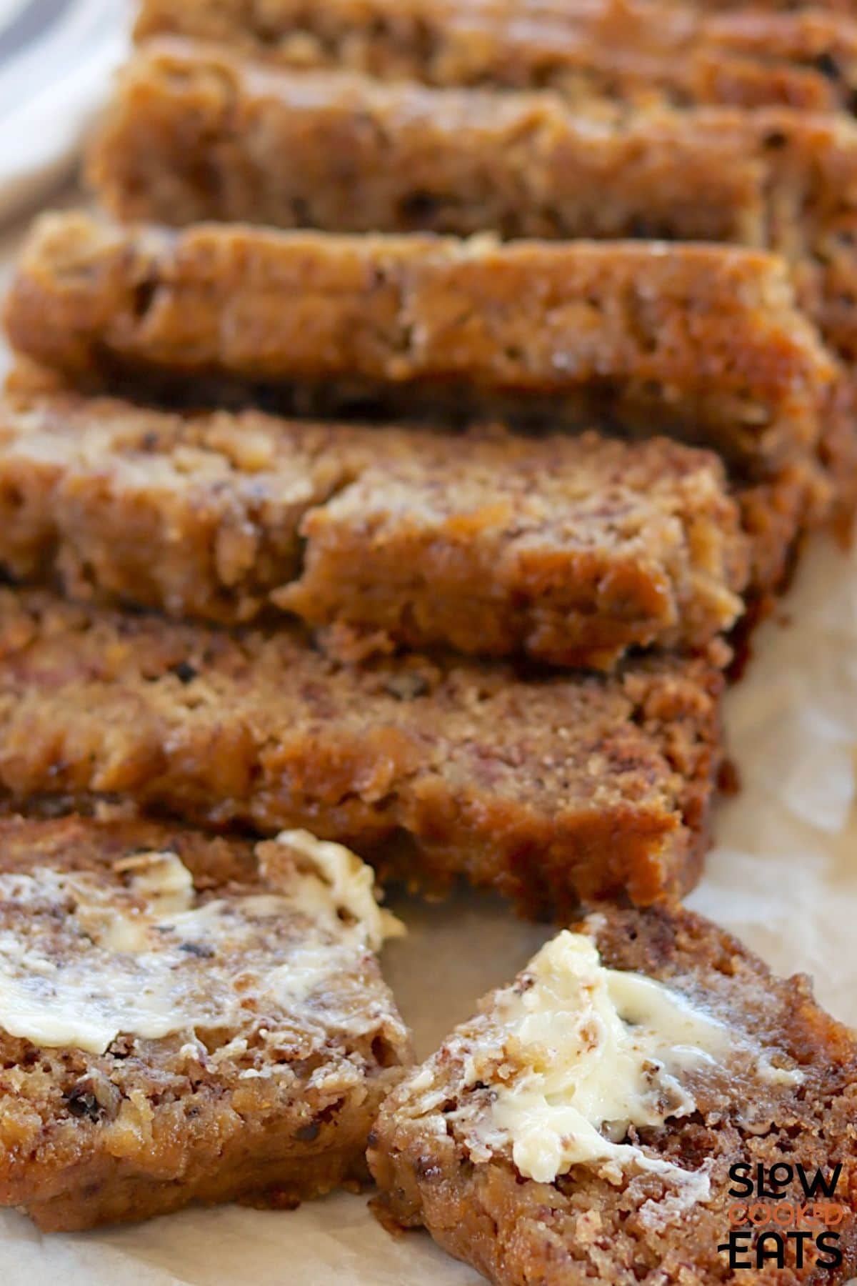 Slow cooked banana bread cut into slices with butter spread on top.