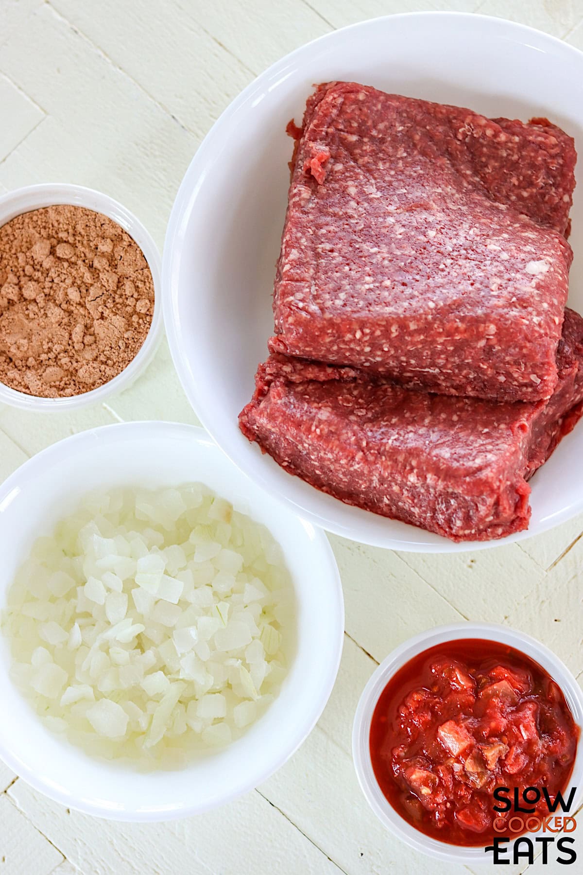 Ingredients needed to make crockpot taco meat on a white countertop.