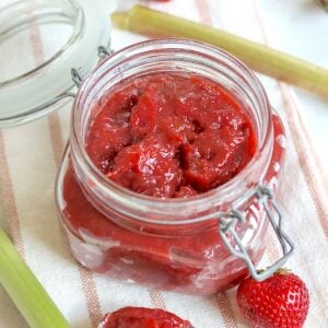 A lidded jar full of slow cooker strawberry rhubarb jam.